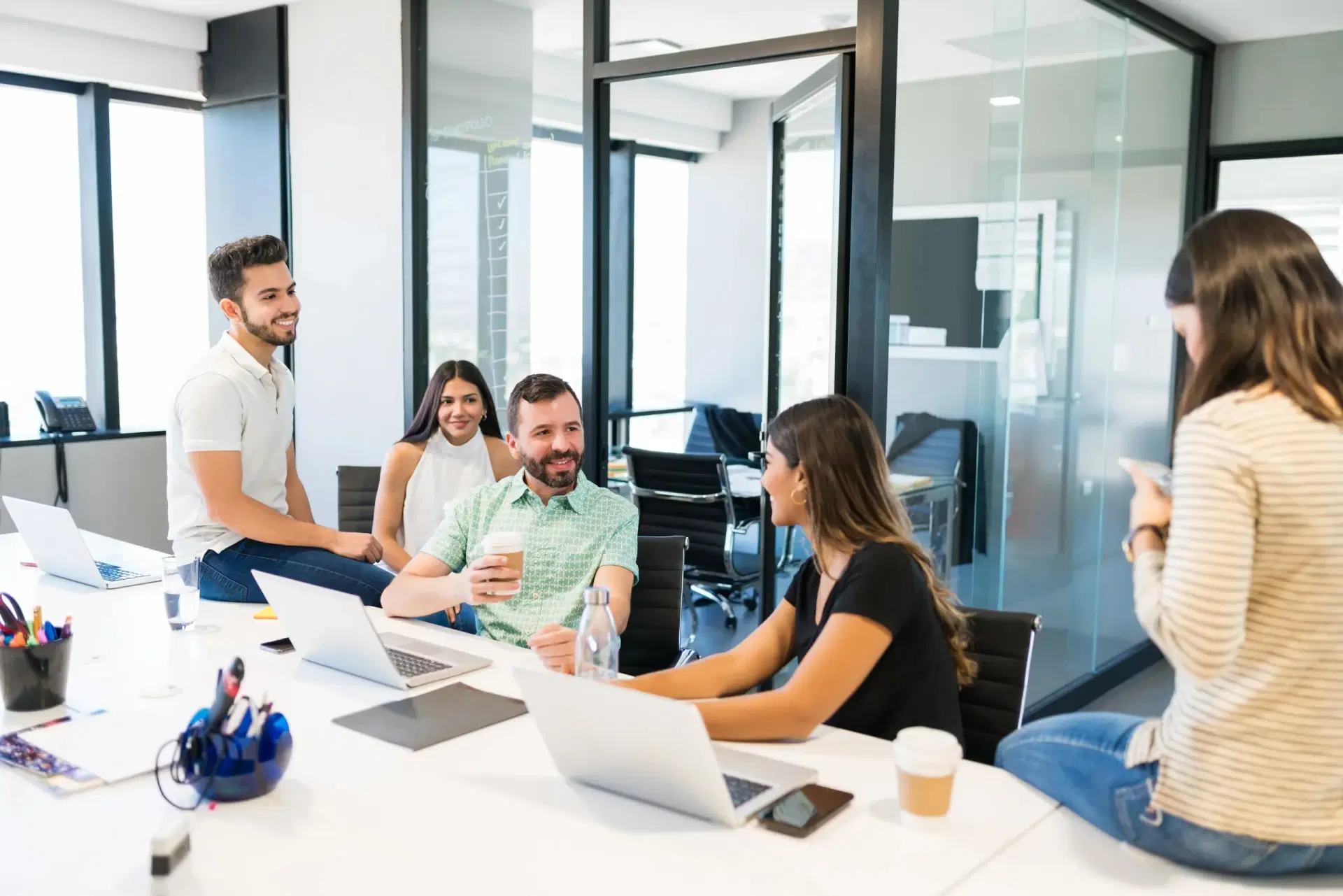People talking around a desk in a glass-walled office